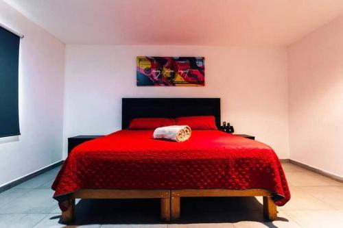 a bedroom with a red bed with a red comforter at El Charco Culiacán in Culiacán