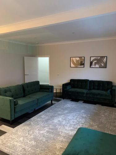 a living room with two green couches and a table at Hillview in Oban