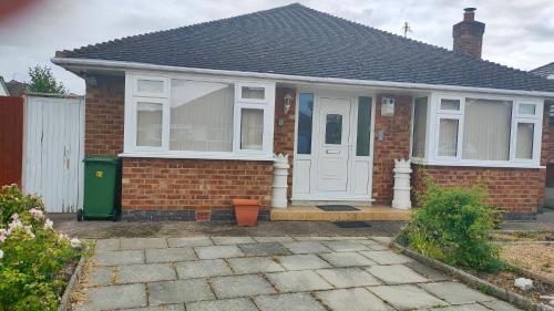 a small brick house with a white door at Linksway House in Birkenhead