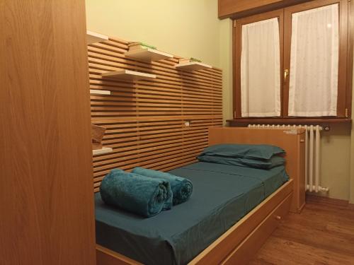 - une chambre avec un lit et un mur en bois dans l'établissement Barzio Paradise, à Barzio