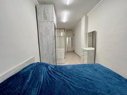 a bedroom with a blue bed and a mirror at Luxuary Apartment in Yerevan,Centre,Saryan Street in Yerevan