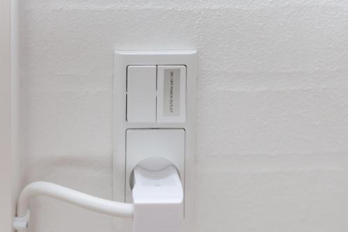 a white button on a wall in a bathroom at Idyllisk lejlighed med plads til 4-personer in Højbjerg