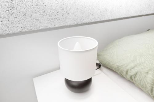 a candle sitting on a table next to a bed at Idyllisk lejlighed med plads til 4-personer in Højbjerg