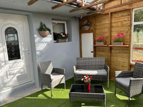 a patio with chairs and a table and a door at Stardust Getaway Tiny-Home E32AK40 in Piltown