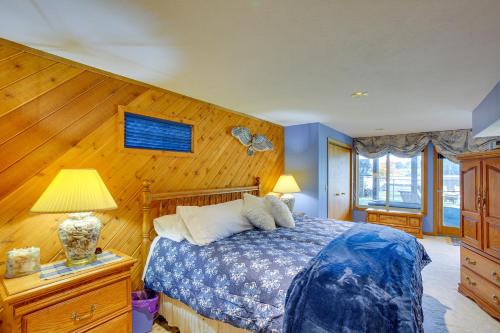 1 dormitorio con 1 cama y pared de madera en Lakefront Cadillac Retreat with Sauna and Boating! en Cadillac