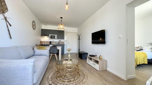 un salon avec un canapé et un lit dans l'établissement L'Ecume, à Fort-Mahon-Plage