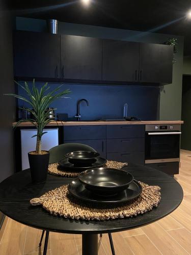 - une cuisine avec une table et deux casseroles dans l'établissement Junglia Suite - Spa & Ciné, à Bourg-en-Bresse