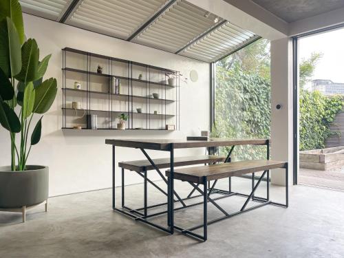 un tavolo e una panca in una stanza con una pianta di Luxury Urban Oasis with Garden and Private Studio a Londra