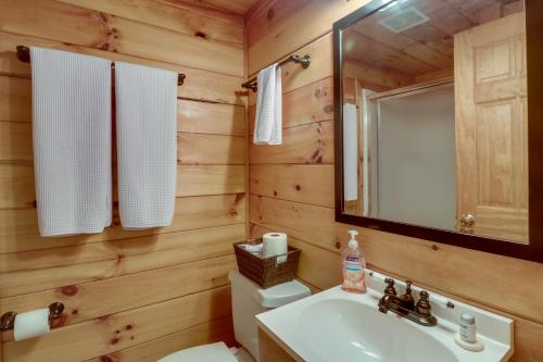 y baño con lavabo, aseo y espejo. en Luray Cabin Near Downtown and Shenandoah River, en Luray