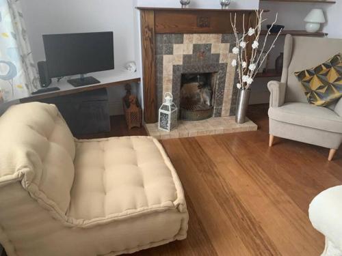 a living room with a couch and a fireplace at Charming 2 double bed cottage style house in Bristol