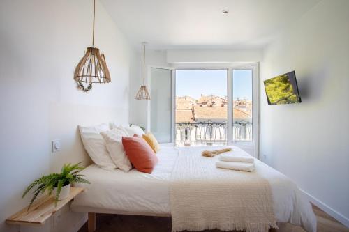 een witte slaapkamer met een groot bed en een raam bij Beautiful Apartment heart of Cannes - Magnifique Coeur de Cannes in Cannes