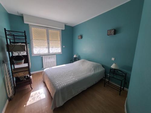 une chambre avec un lit et un mur bleu dans l'établissement New Centre ville 3P clim, à Antibes