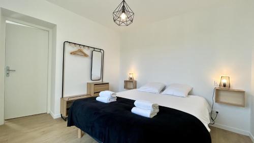 une chambre avec un grand lit avec des serviettes dessus dans l'établissement L'Escale, à Fort-Mahon-Plage