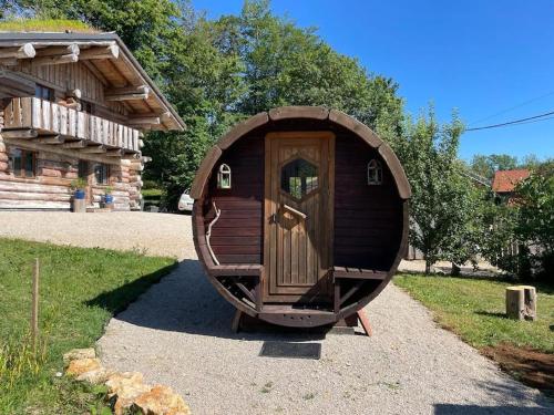 a small wooden hobbit house in front of a cabin at Lagarta , la buche in Étival