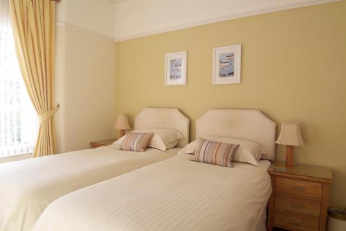 two beds sitting next to each other in a bedroom at The Baytree - Exclusively for Adults in Torquay