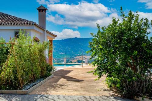 a villa with a swimming pool and mountains in the background at Casa Rural Lomillas de Canca in Alora