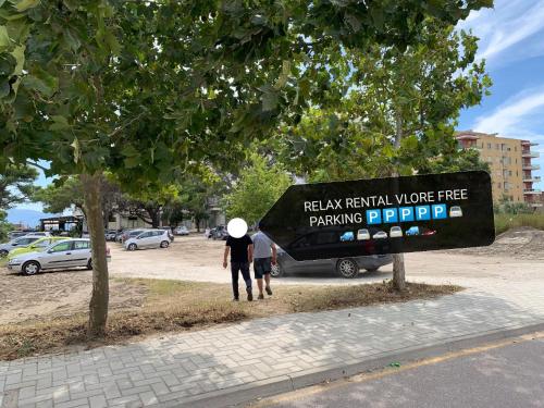 twee mensen die naast een busje lopen met een bord bij Relax Rental in Vlorë