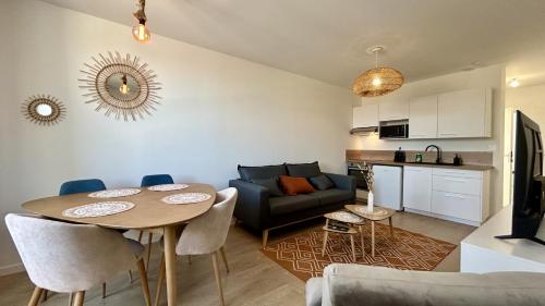 un salon avec une table et un canapé dans l'établissement L'Horizon, à Fort-Mahon-Plage