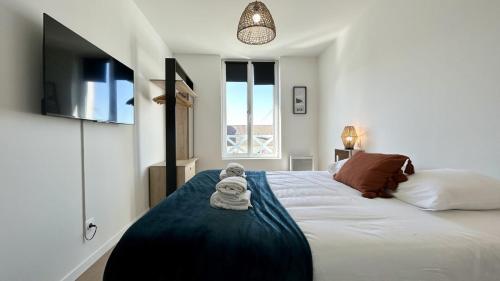 une chambre avec un lit avec une serviette dessus dans l'établissement L'Horizon, à Fort-Mahon-Plage