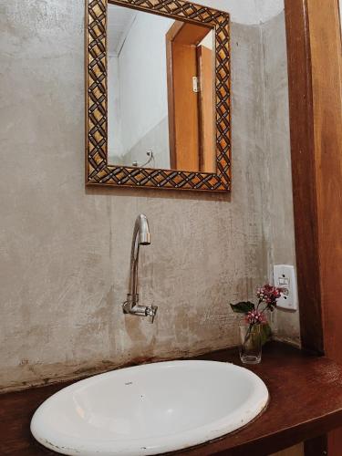 a bathroom with a sink and a mirror at Pousada Clara Caraíva in Caraíva