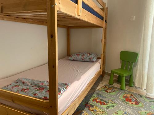 ein Schlafzimmer mit einem Etagenbett und einem grünen Stuhl in der Unterkunft COZY & QUIET CITY APARTMENT in Tríkala