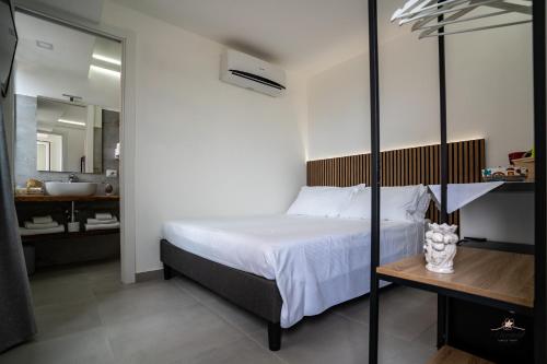 a bedroom with a bed and a bathroom with a sink at Humboldt Luxury Rooms Taormina in Taormina