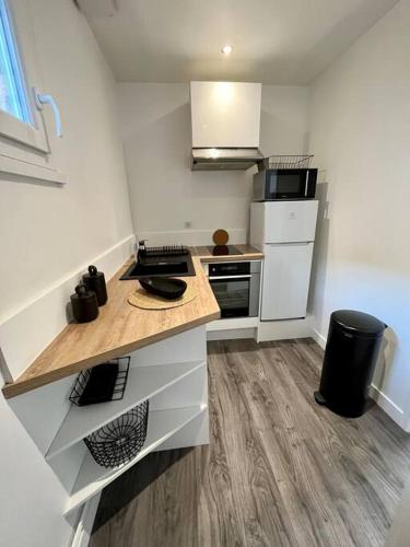 - une petite cuisine avec des appareils blancs et un comptoir en bois dans l'établissement Maisonnette à la campagne avec jardinet, à Ennery