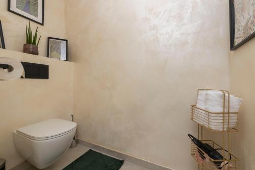 a bathroom with a toilet and towels on the wall at City Apartments Wolfgangsee in St. Wolfgang