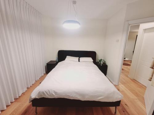 a bedroom with a large bed with white sheets at תמר על הים in Bat Yam