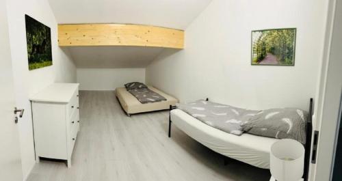a bedroom with two beds and a desk in it at Moderne Maisonettewohnung/2 Zimmer/Küche/Bad #1 in Markt Schwaben