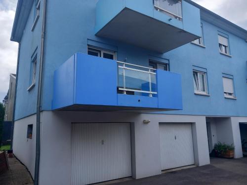 - un bâtiment bleu avec un balcon en haut dans l'établissement Appartement 3 pièces avec balcon, à Rhinau