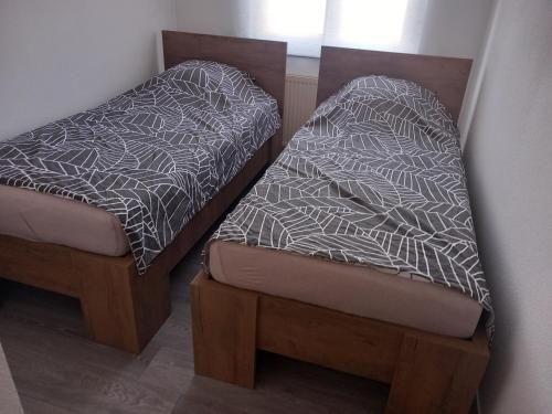 two beds sitting next to each other in a room at Appartement 3 pièces avec balcon in Rhinau