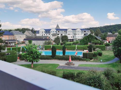 - une vue sur un complexe avec une piscine et un bâtiment dans l'établissement Le Repos'Han, à Han-sur-Lesse