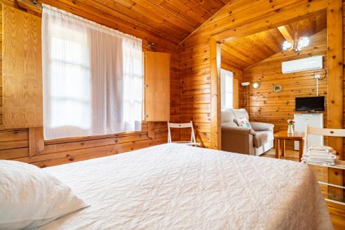 ein Schlafzimmer mit einem Bett in einem Holzzimmer in der Unterkunft Cortijo Huerta Dorotea in Prado del Rey