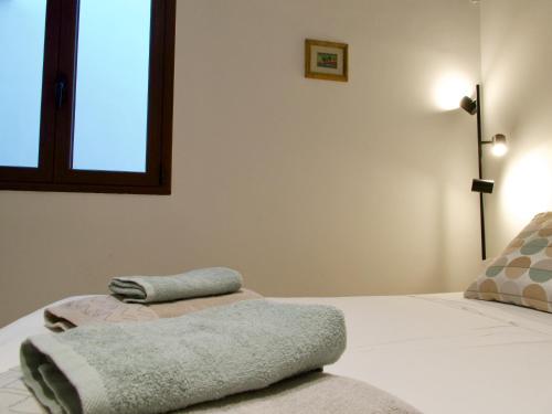 1 dormitorio con 1 cama con 2 toallas en Newly Renovated-Holiday house with large garden, en Galatina