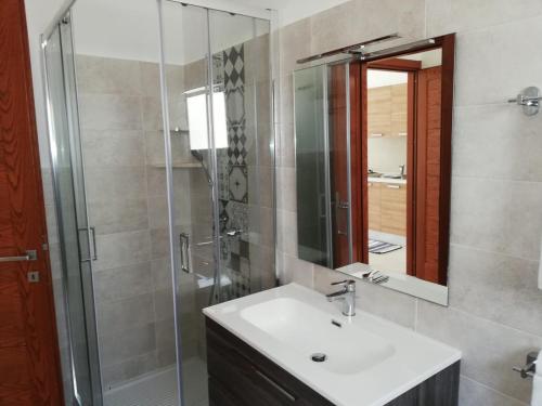 a bathroom with a sink and a shower and a mirror at Body and Soul in Cala Gonone