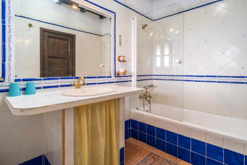 a bathroom with a sink and a mirror and a tub at Cortijo Huerta Dorotea in Prado del Rey