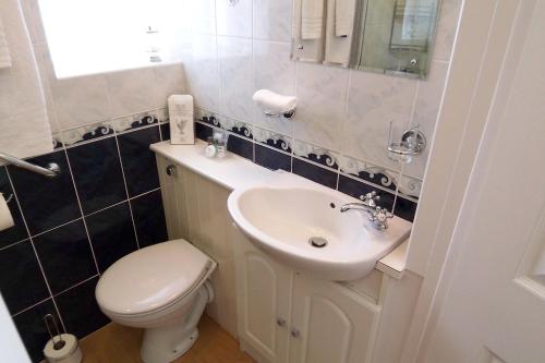 a bathroom with a white toilet and a sink at The Baytree - Exclusively for Adults in Torquay