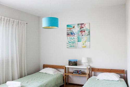 1 dormitorio con 2 camas y luz azul en Okira beach house, en Aguda