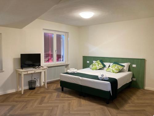 1 dormitorio con 1 cama, TV y ventana en Locanda Il Cavallino en Valeggio sul Mincio