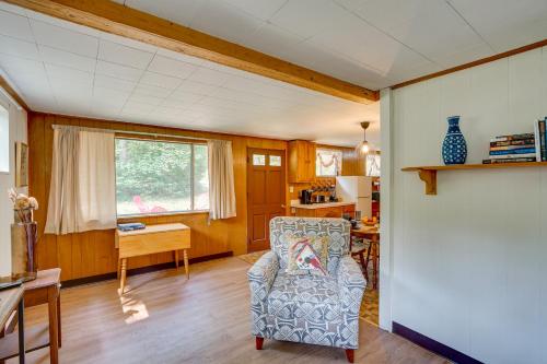 ein Wohnzimmer mit einem Stuhl und eine Küche in der Unterkunft Cozy Becket Cottage Escape with Lake Access! in Becket