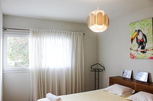 1 dormitorio con cama y ventana en Okira beach house, en Aguda