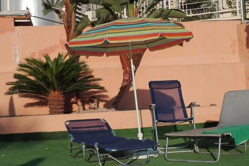 two chairs and an umbrella in a room at Torremar 17 vistas al mar Benidorm in Benidorm