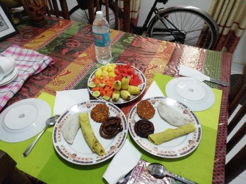 einen Tisch mit Teller mit Lebensmitteln und eine Schale mit Obst in der Unterkunft BAS Balcony in Anuradhapura