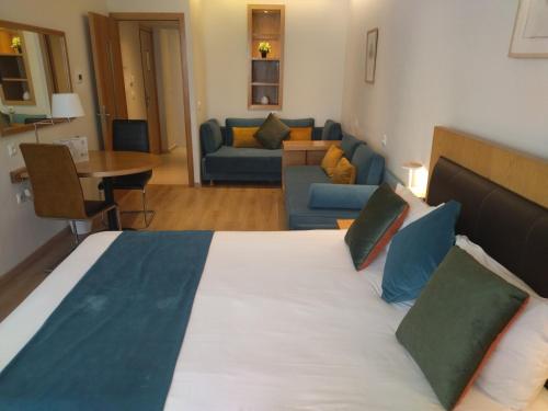 a bedroom with a large bed and a living room at Le Pietri Urban Hotel in Rabat