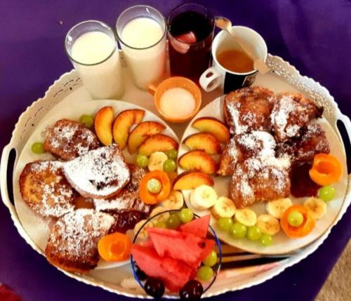 a plate of food with pastries and fruit and drinks at Къща за гости Вълчеви Несебър in Nesebar