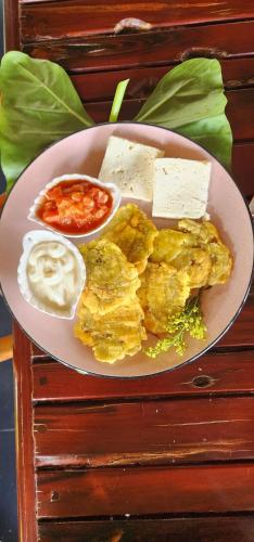 a plate of food with eggs and cheese on a table at Hotel Casa Barlovento, Parque Tayrona in Los Naranjos