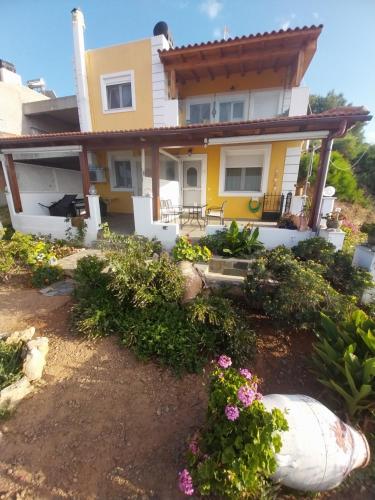 a house with flowers in front of it at Roussa's View Apartments in Sitia