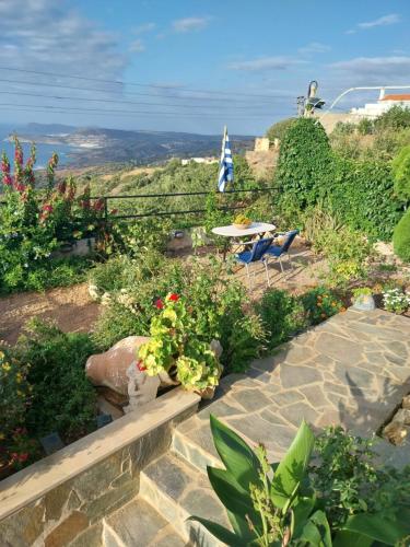 a patio with a table and chairs and flowers at Roussa's View Apartments in Sitia