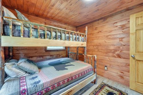 a bedroom with two bunk beds in a log cabin at Cozy Ellicottville Cabin with Water Views - Near Ski in Ellicottville